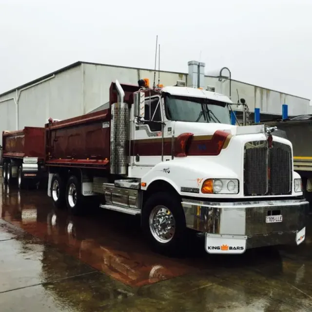 A kenworth dump truck is parked in front of a building