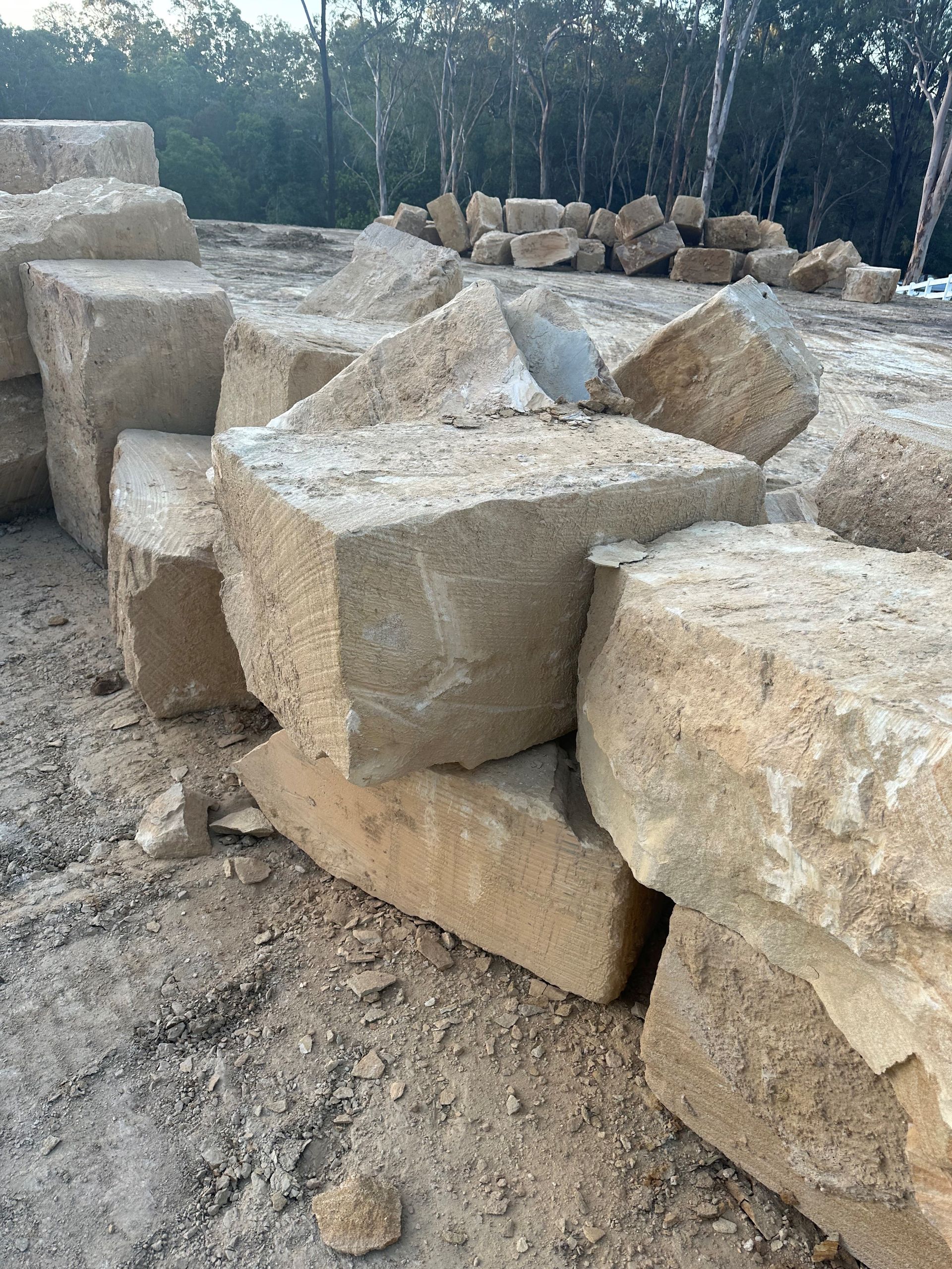 A pile of sandstone rocks sitting on top of each other in the dirt.