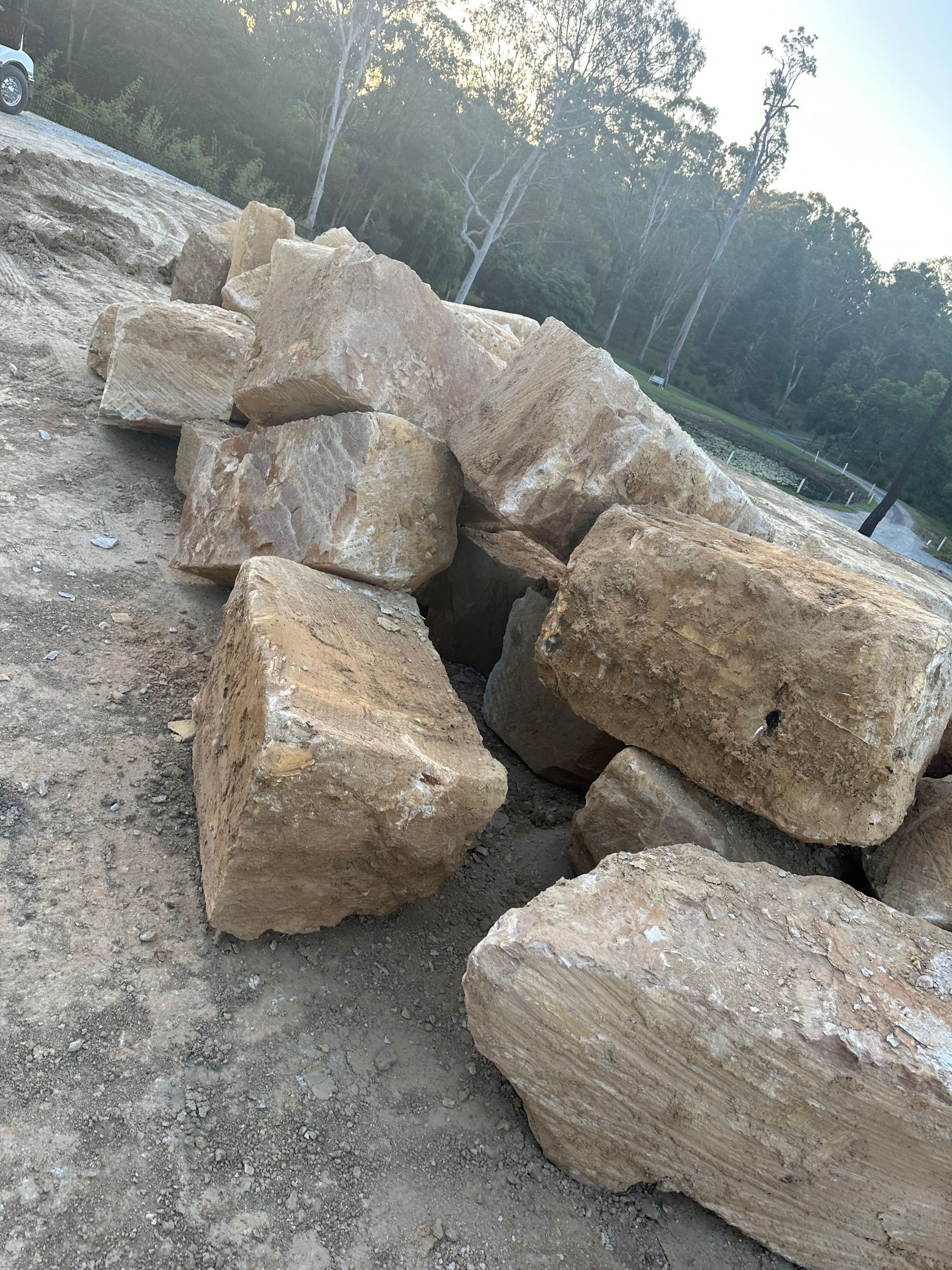 A pile of sandstone rocks sitting on top of a dirt field.