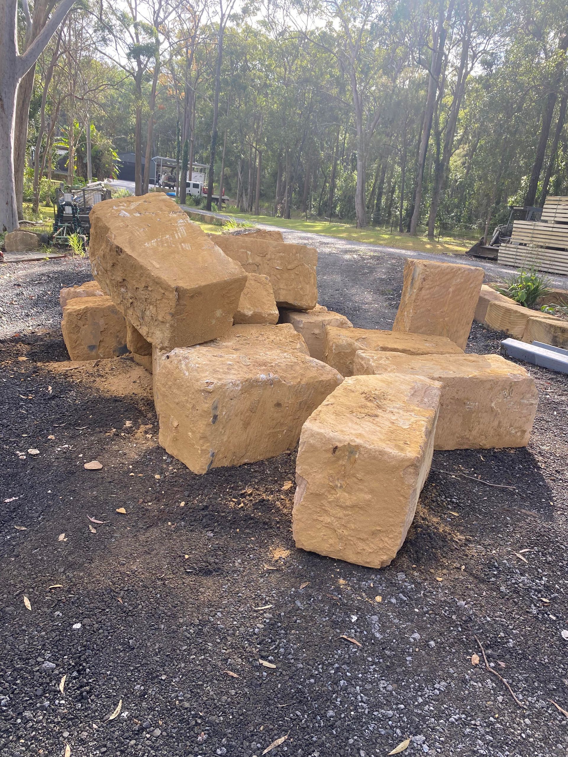 A pile of sandstone bricks sitting on top of a pile of gravel.