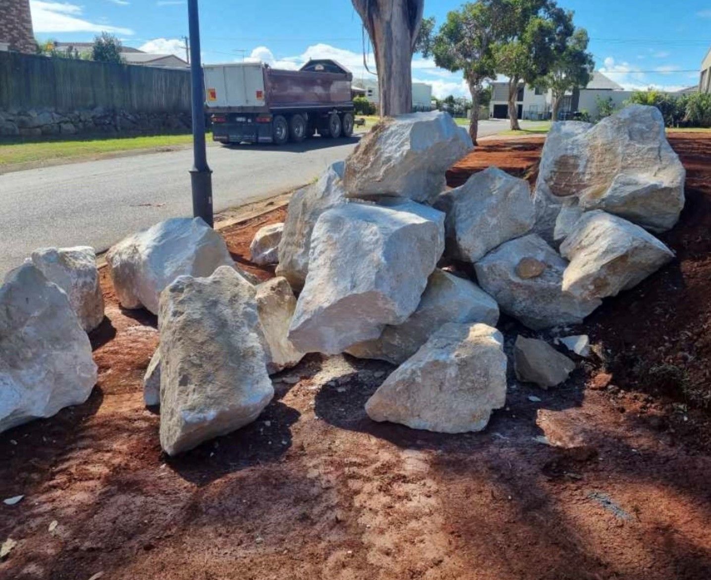 A pile of sandstone rocks is sitting on the ground next to a truck.