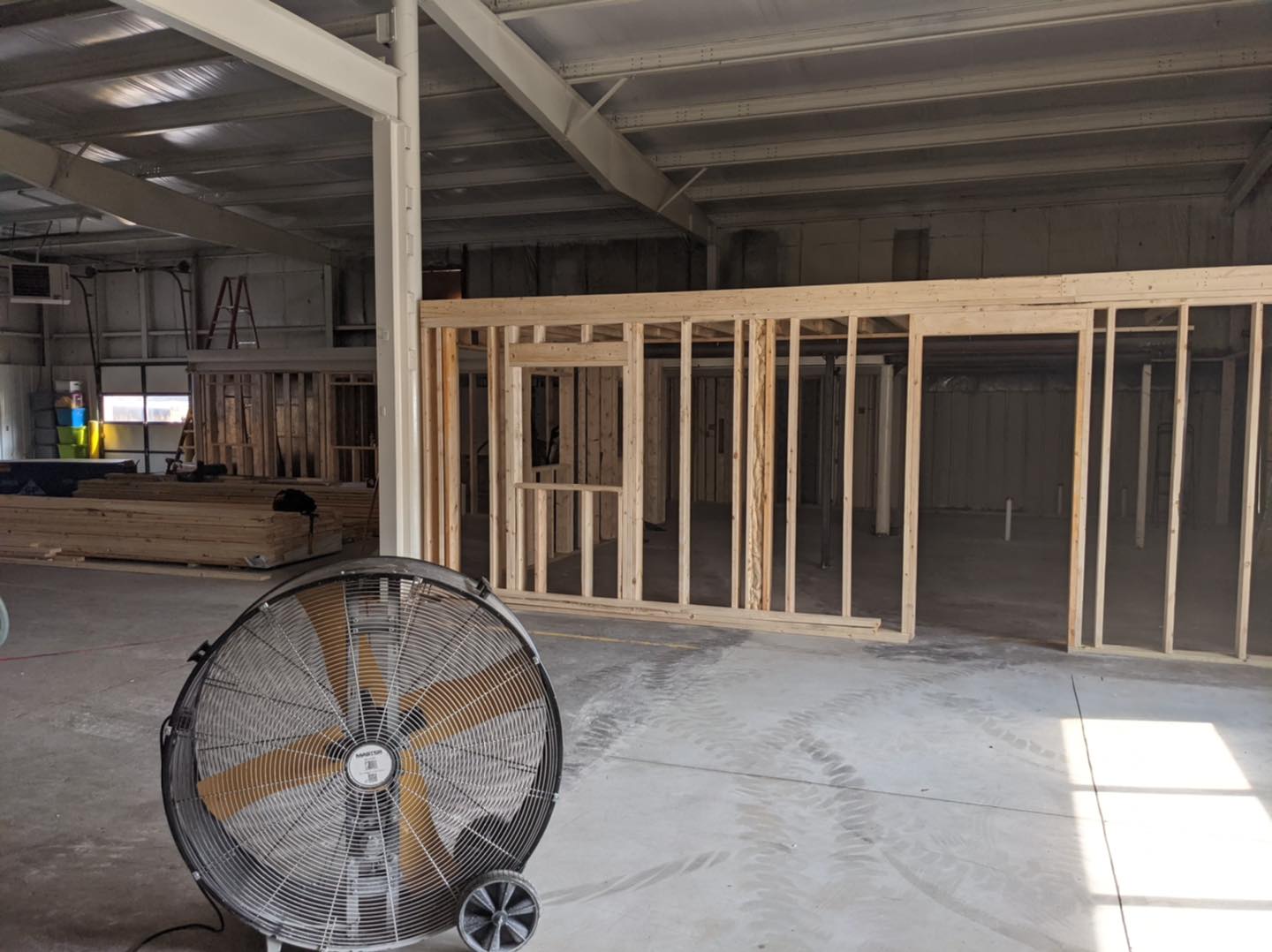 A fan is sitting in the middle of a building under construction.