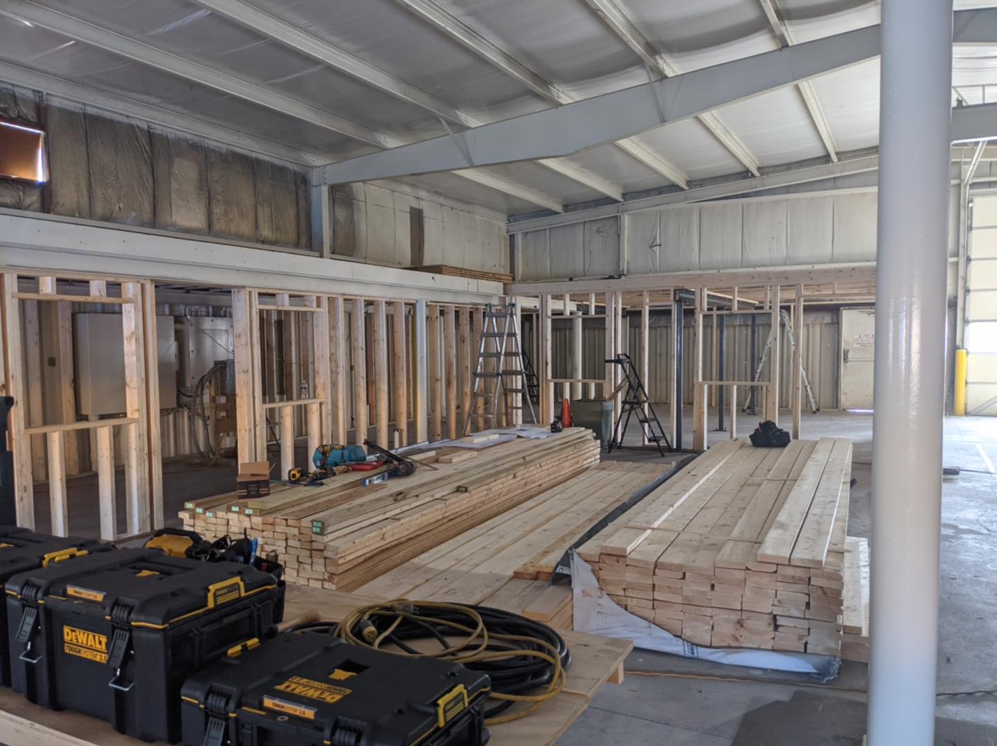 A building under construction with a lot of wood and tools on the floor.