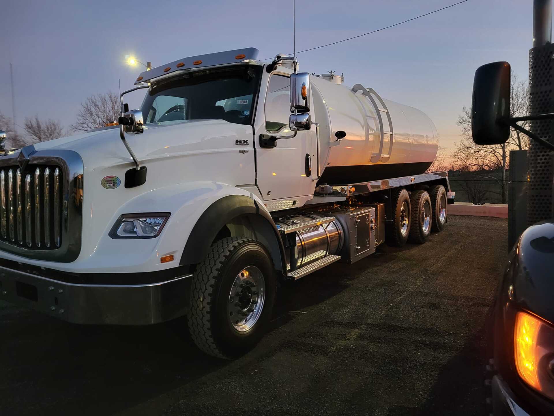 A white semi truck is parked on the side of the road.