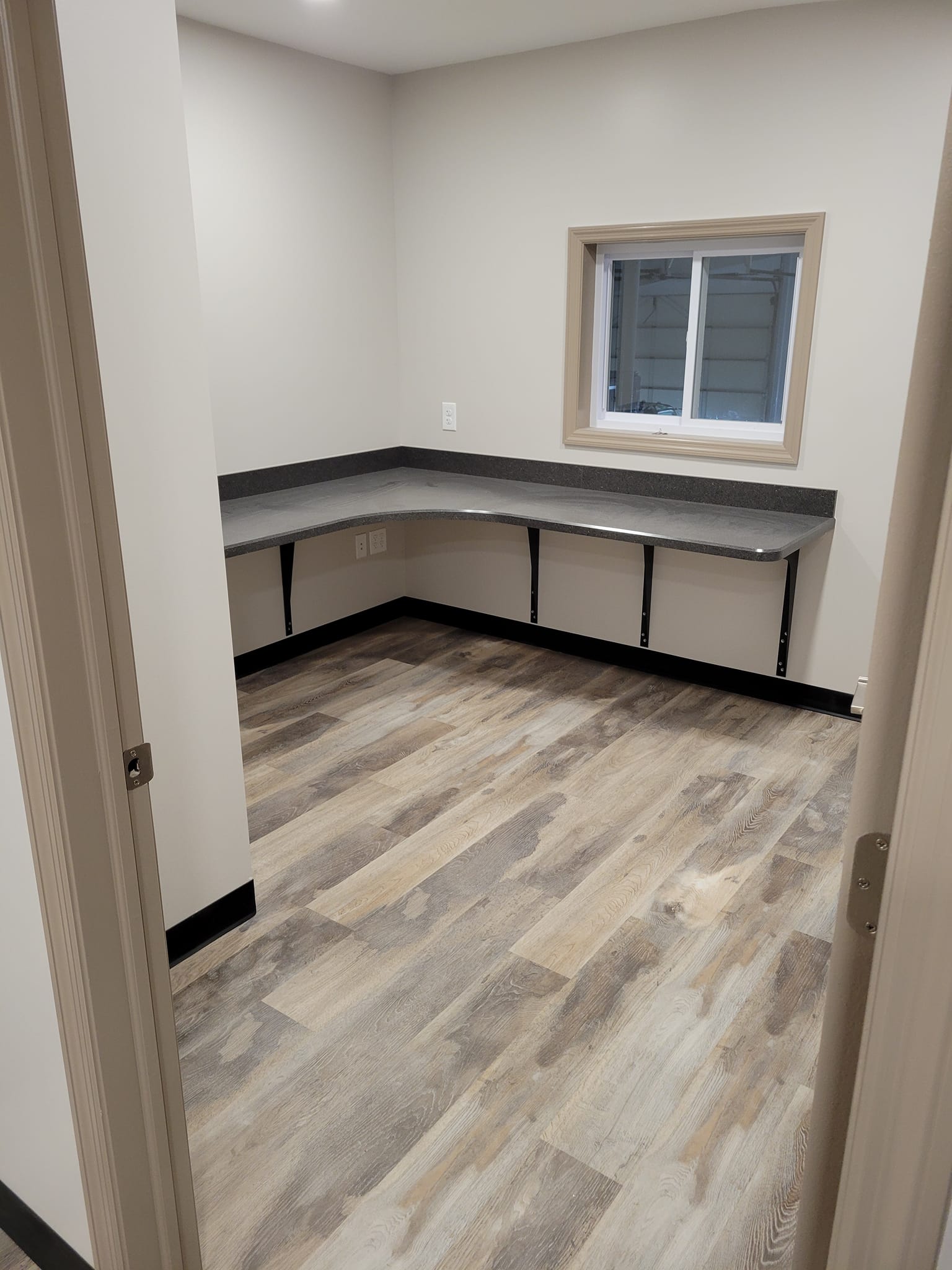 A room with a wooden floor and a window.