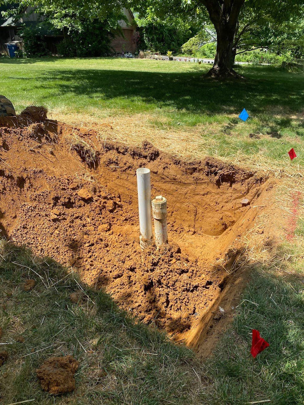 A hole in the ground with a pipe in it.