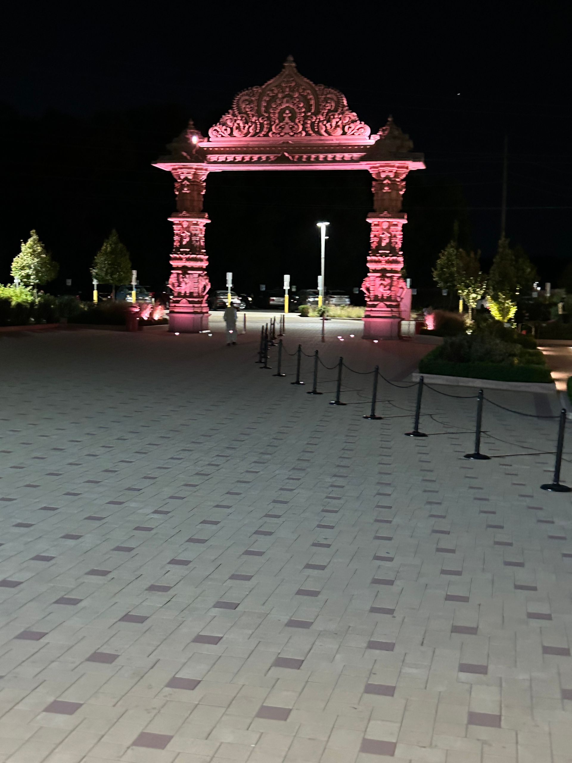A large pink archway is lit up at night
