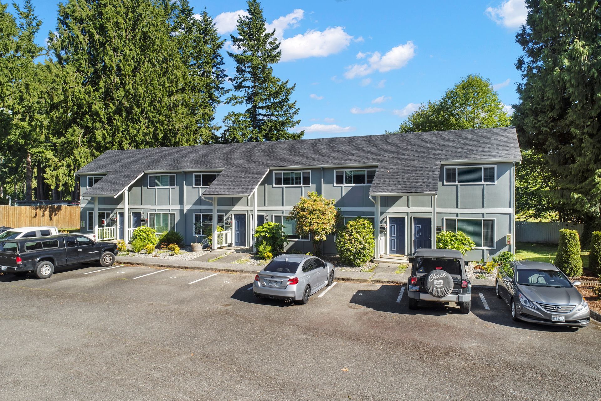A row of cars are parked in front of a building