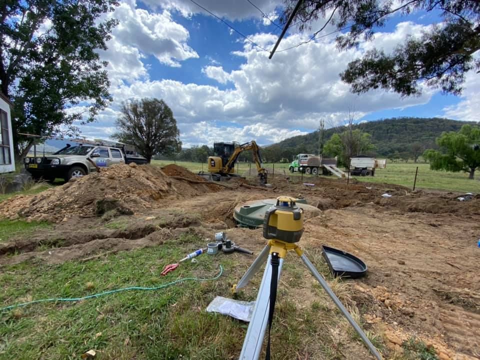 Two Black Tanks Are Sitting in a Hole in the Ground — Peel Valley Plumbing In Hillvue, NSW