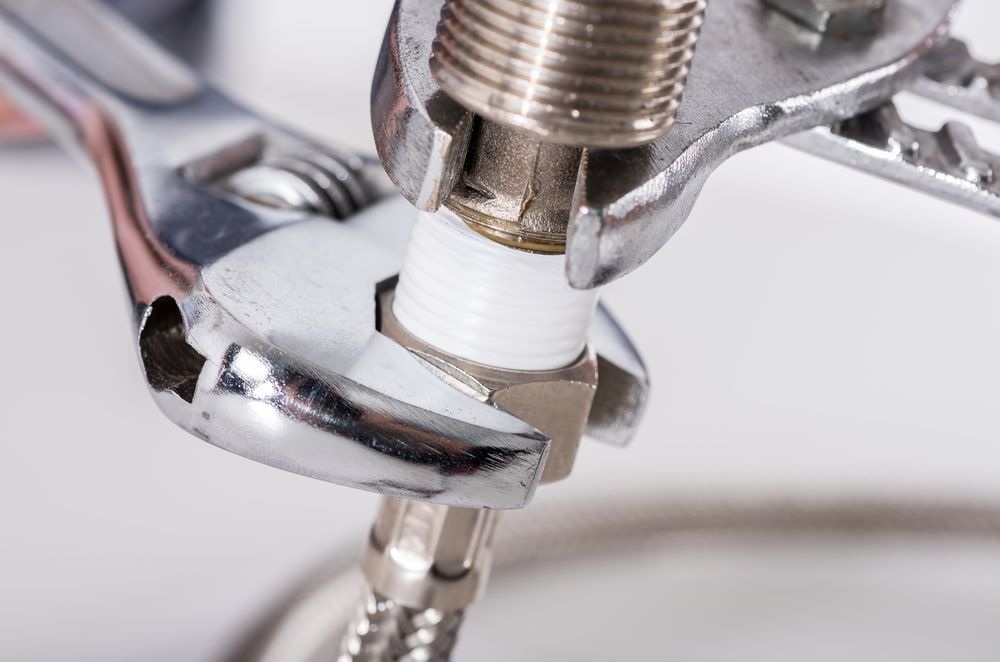 A Wrench Is Being Used To Fix A Faucet — Peel Valley Plumbing In Hillvue, NSW
