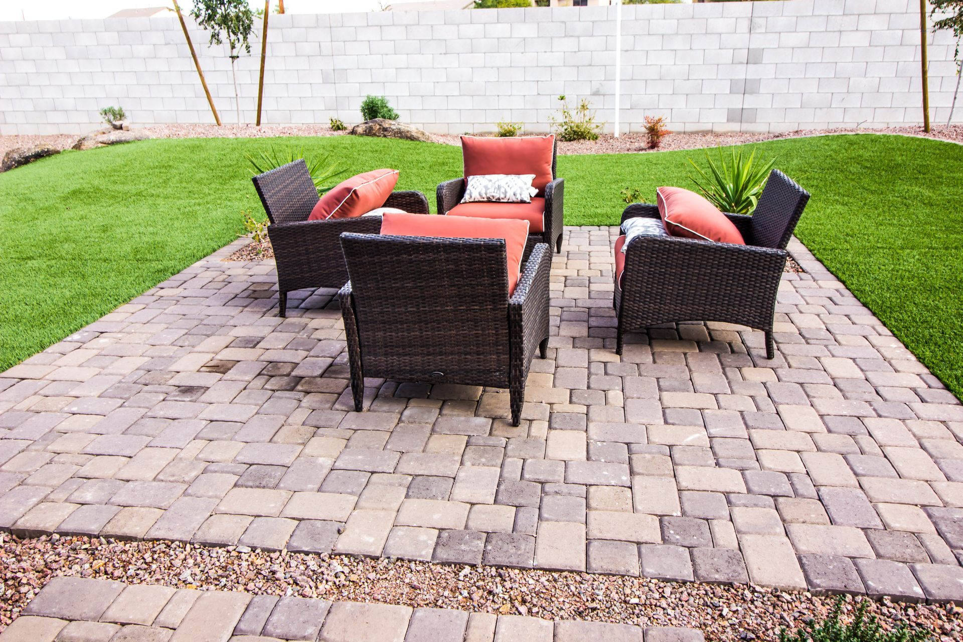 A patio with wicker furniture and a couch and chairs on it.