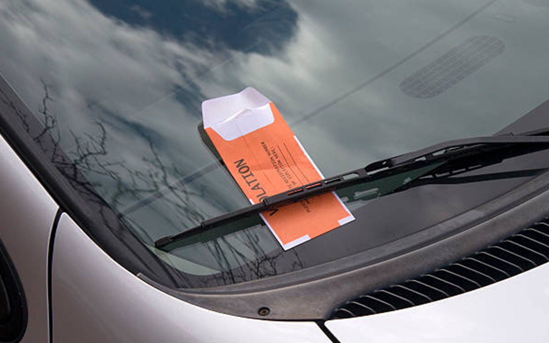 A parking ticket on the windshield of a car