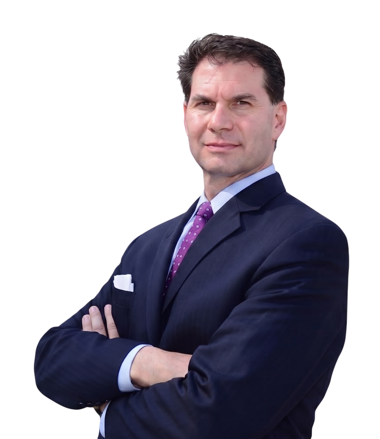 Man in a dark suit with folded arms, standing against a white background.
