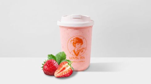 Pink strawberry smoothie cup with strawberries on a white background
