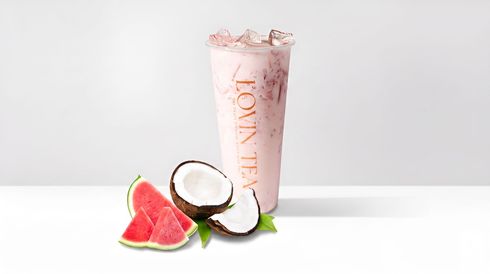 Pink smoothie in a clear glass with coconut and watermelon slices on a white background
