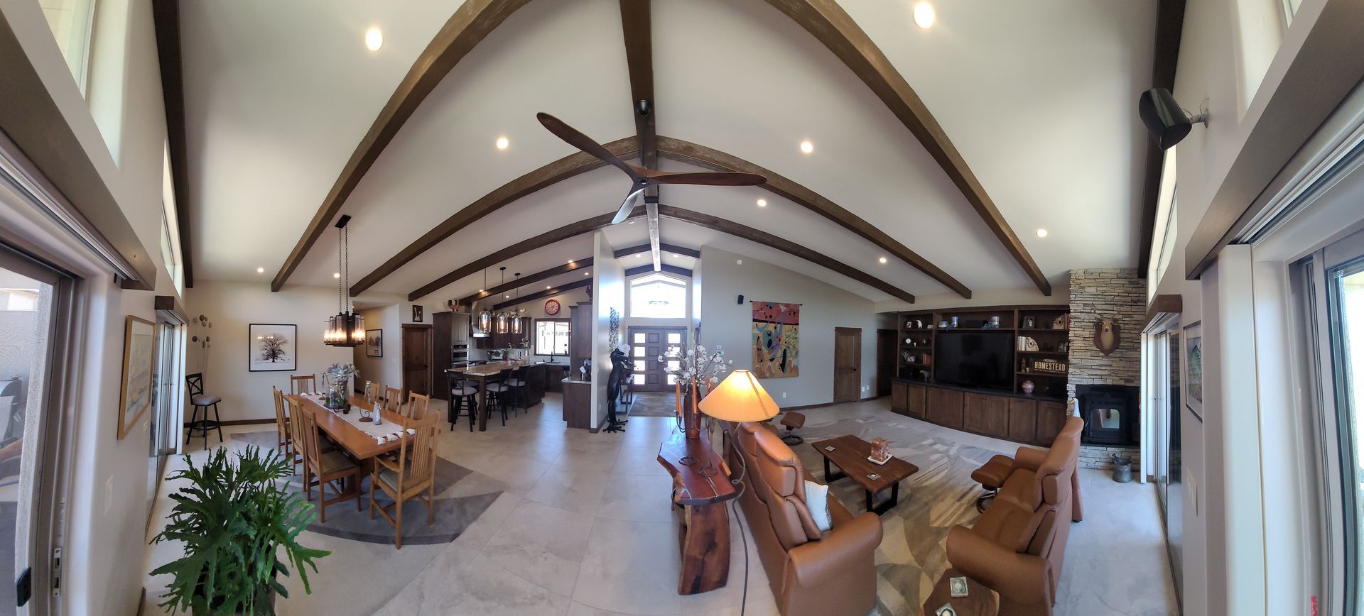 A living room with a couch , chair , coffee table and ceiling fan.