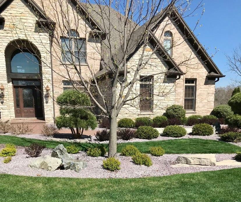 A large brick house with a lush green lawn in front of it.