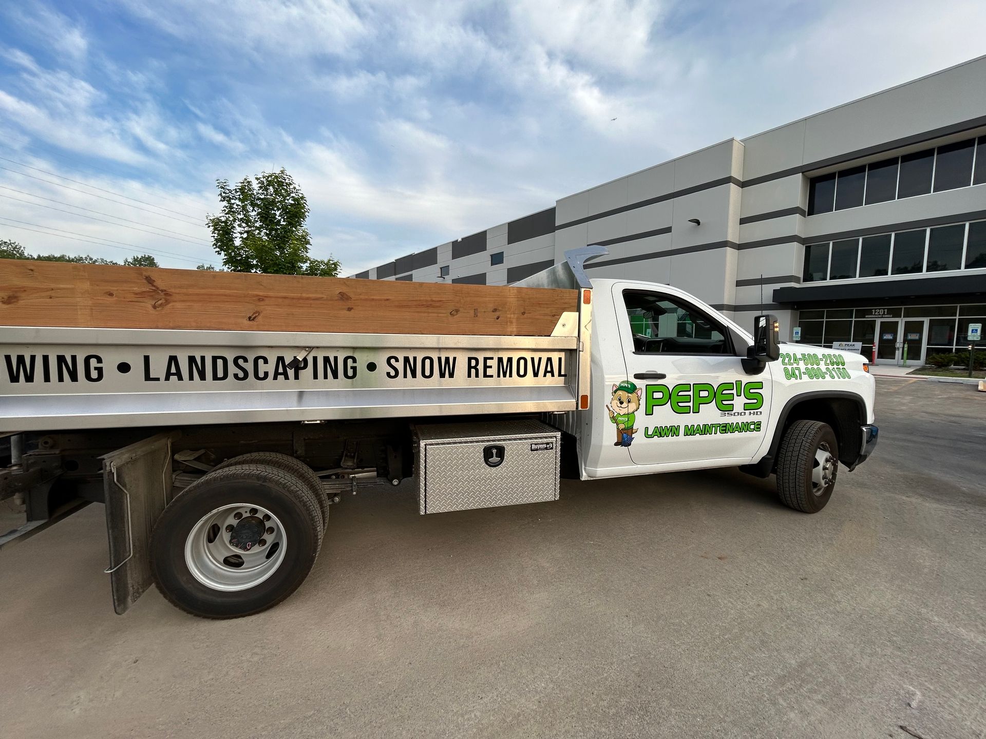 White landscaping truck with PEPE’S logo parked outside an office building