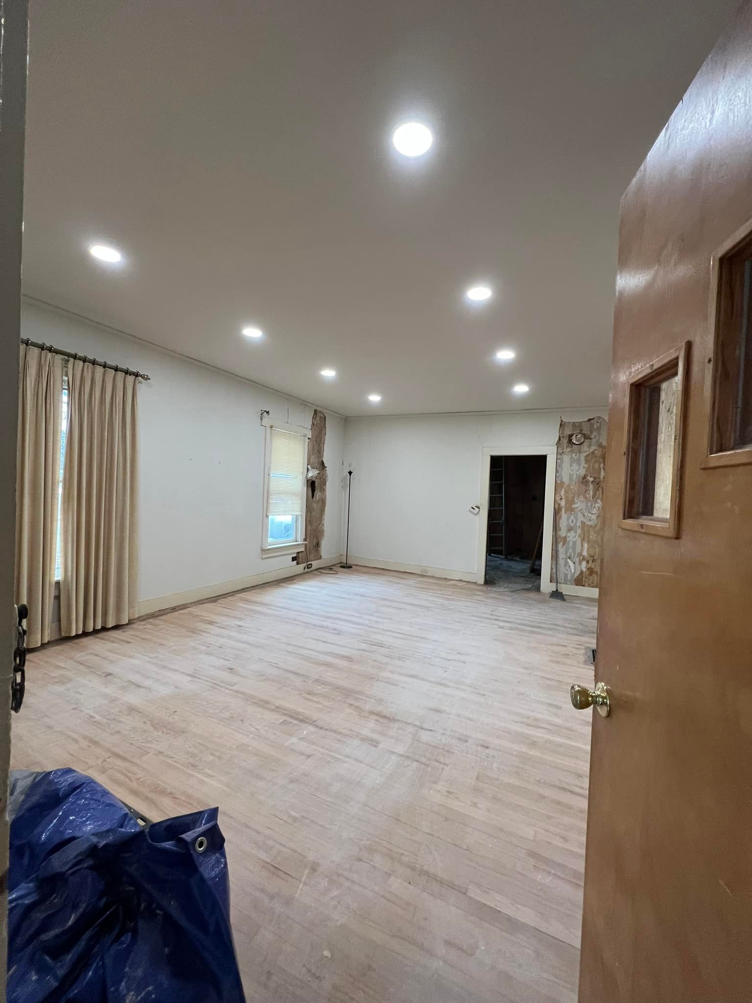 A man wearing a hard hat and goggles is standing in a room.