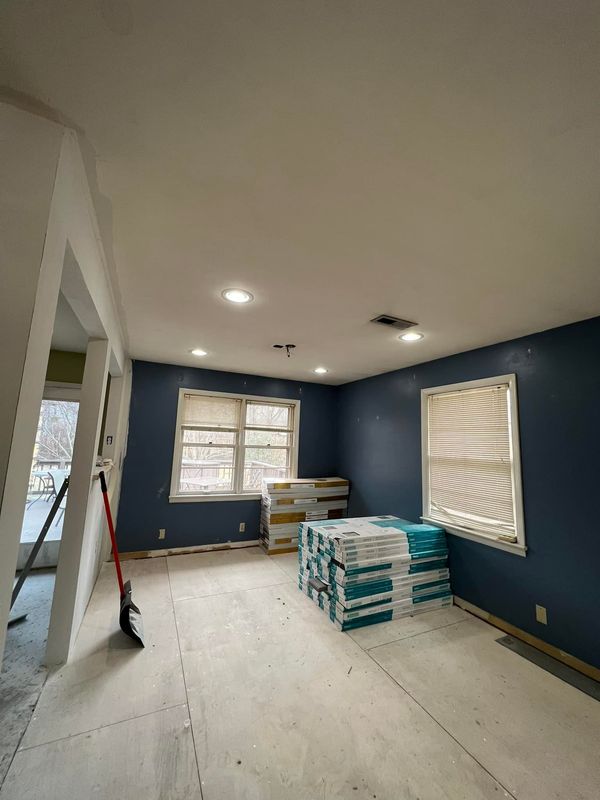 A man wearing a hard hat and goggles is standing in a room.