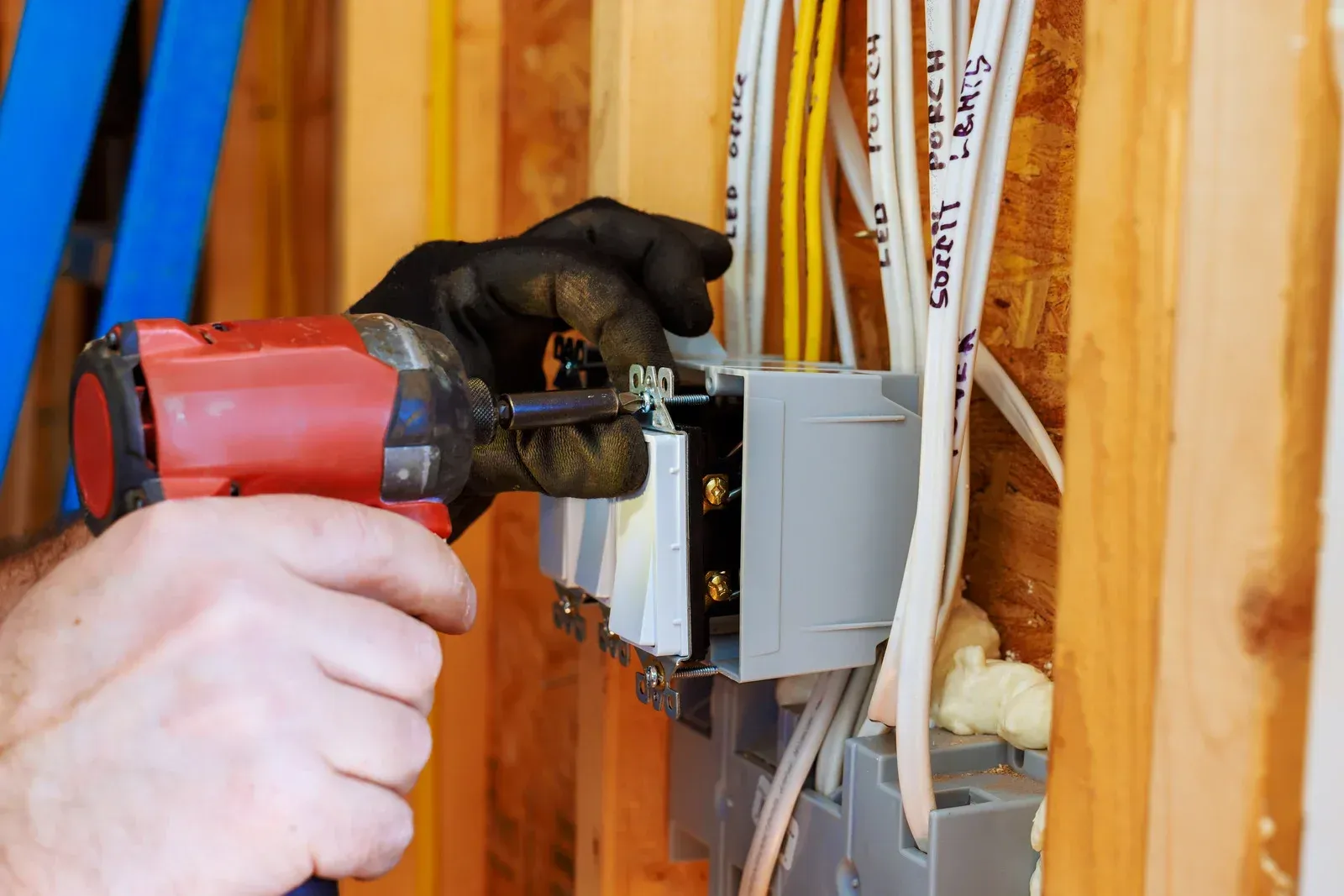 A man wearing a hard hat and goggles is standing in a room.