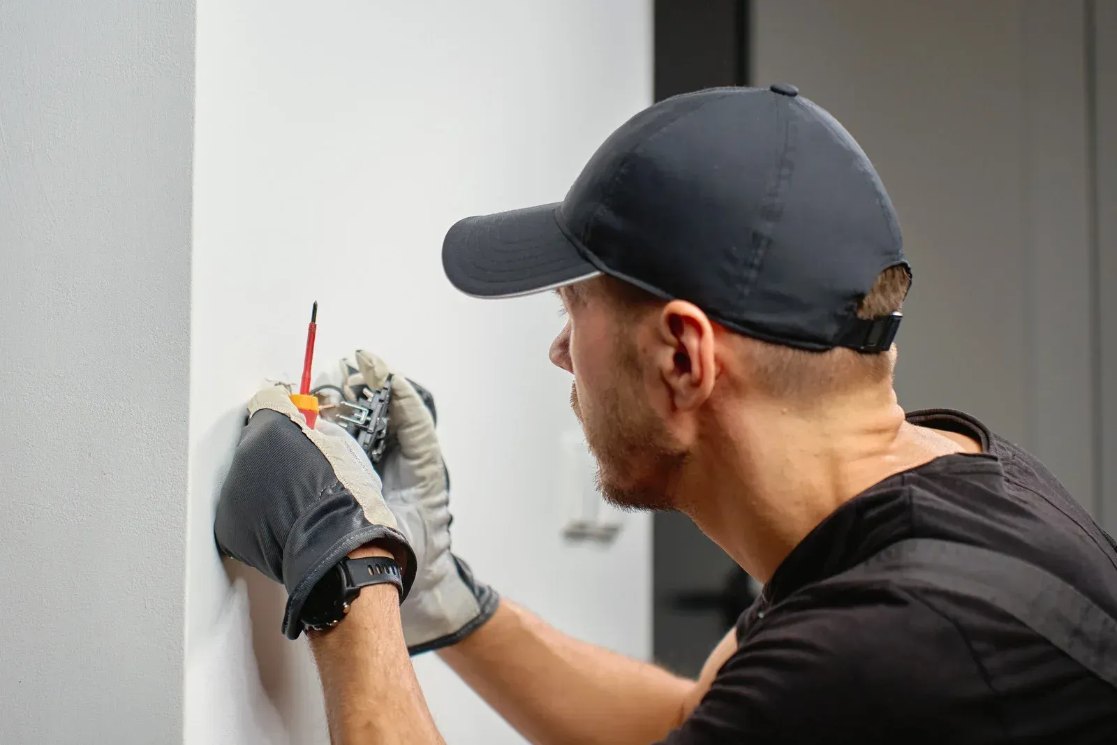 A man wearing a hard hat and goggles is standing in a room.