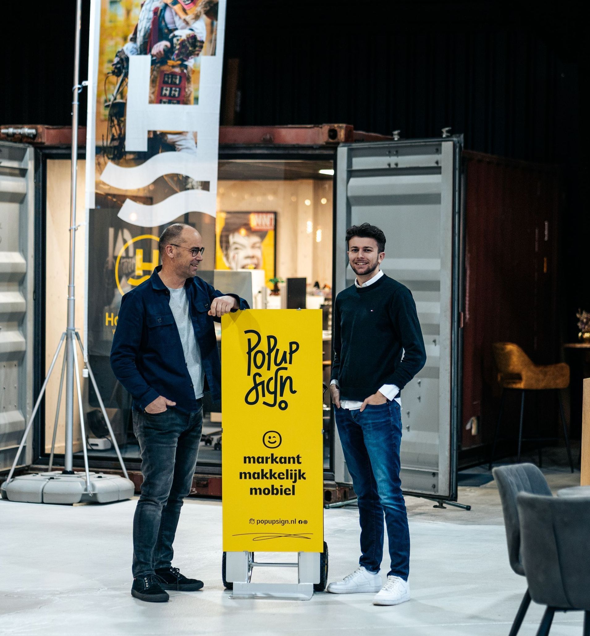 Jan en Mees staan naast popup sign.