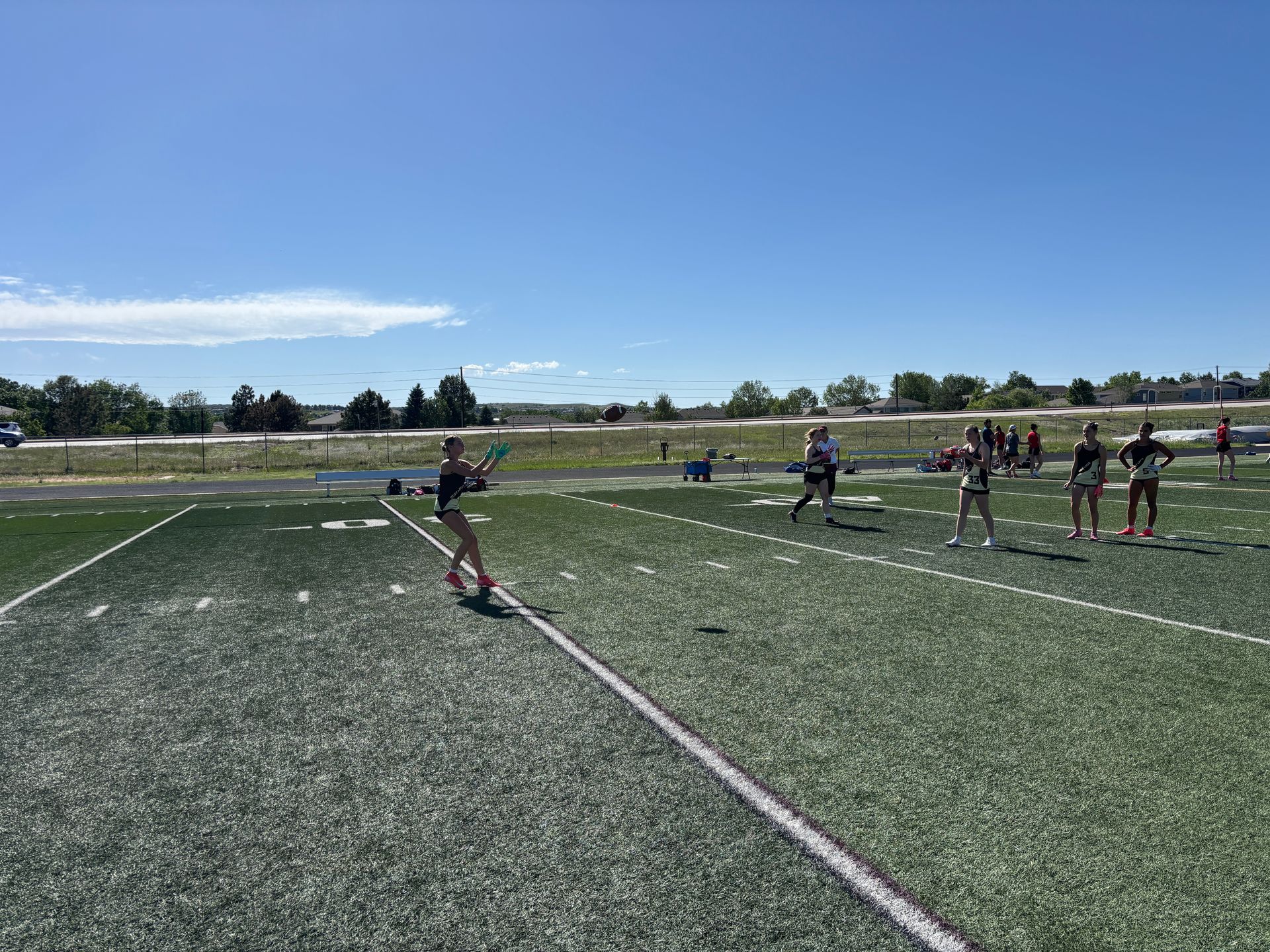 Soccer players lined up on a sunny turf field, preparing for a kick-off.