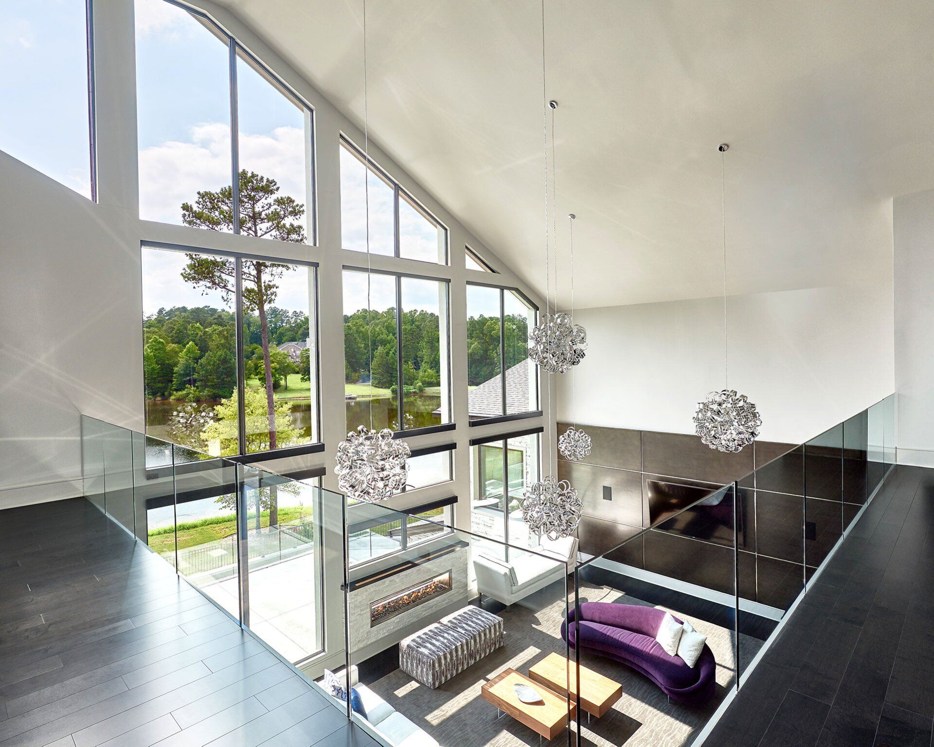 A living room with a lot of windows and a purple couch