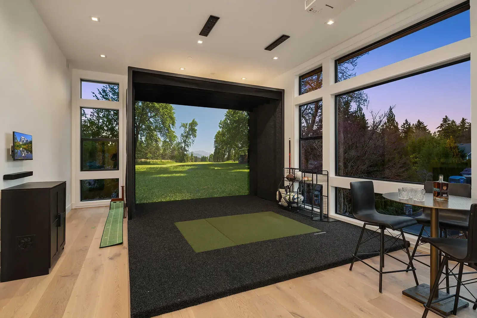 There is a golf simulator in the middle of the room.