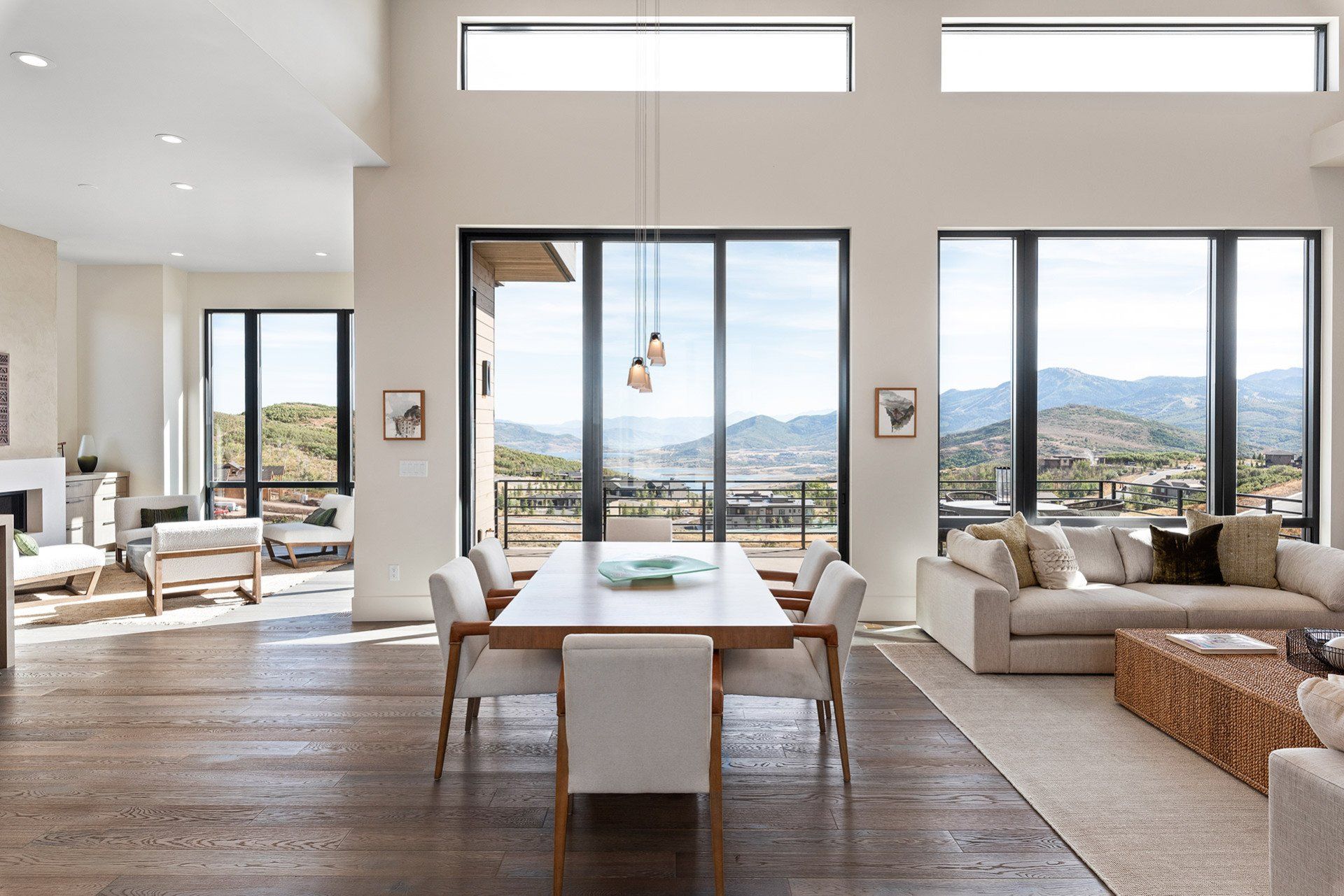 A living room with a dining table and chairs and a view of the mountains.