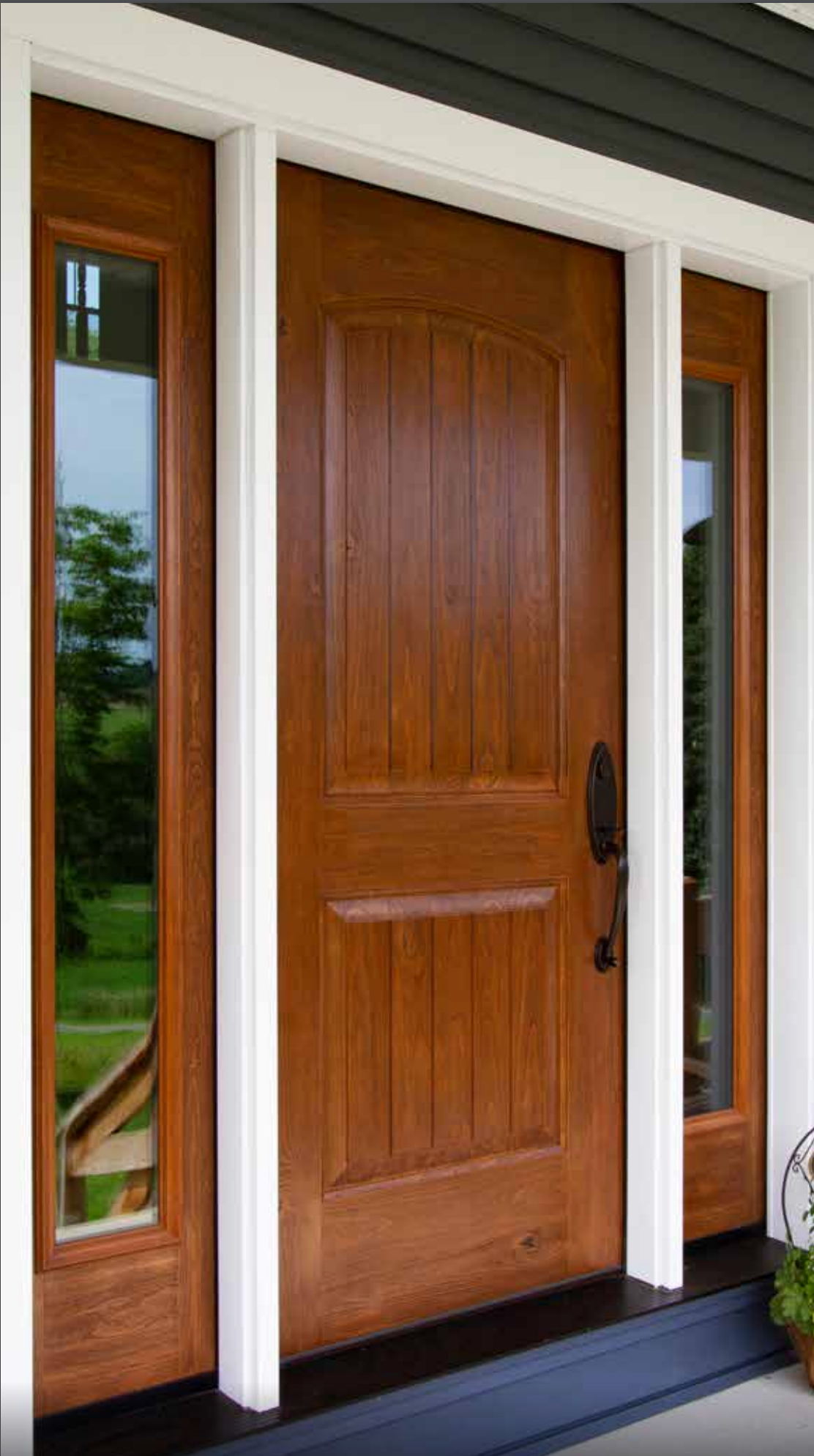 A wooden door with a white trim is on a porch.