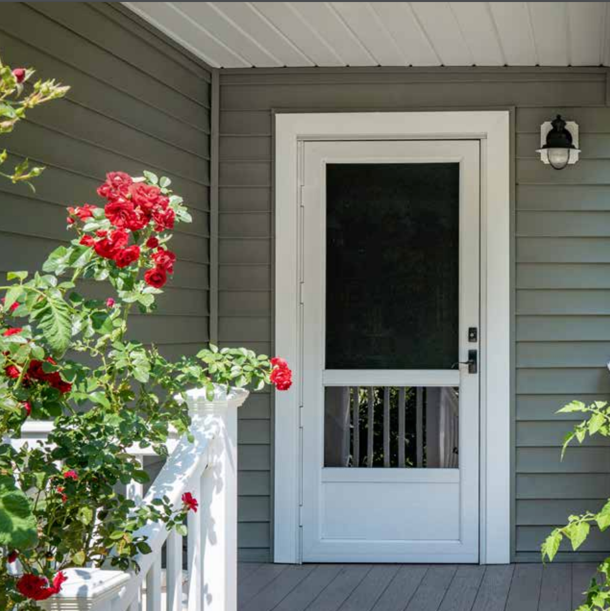 A porch with flowers and a screen door