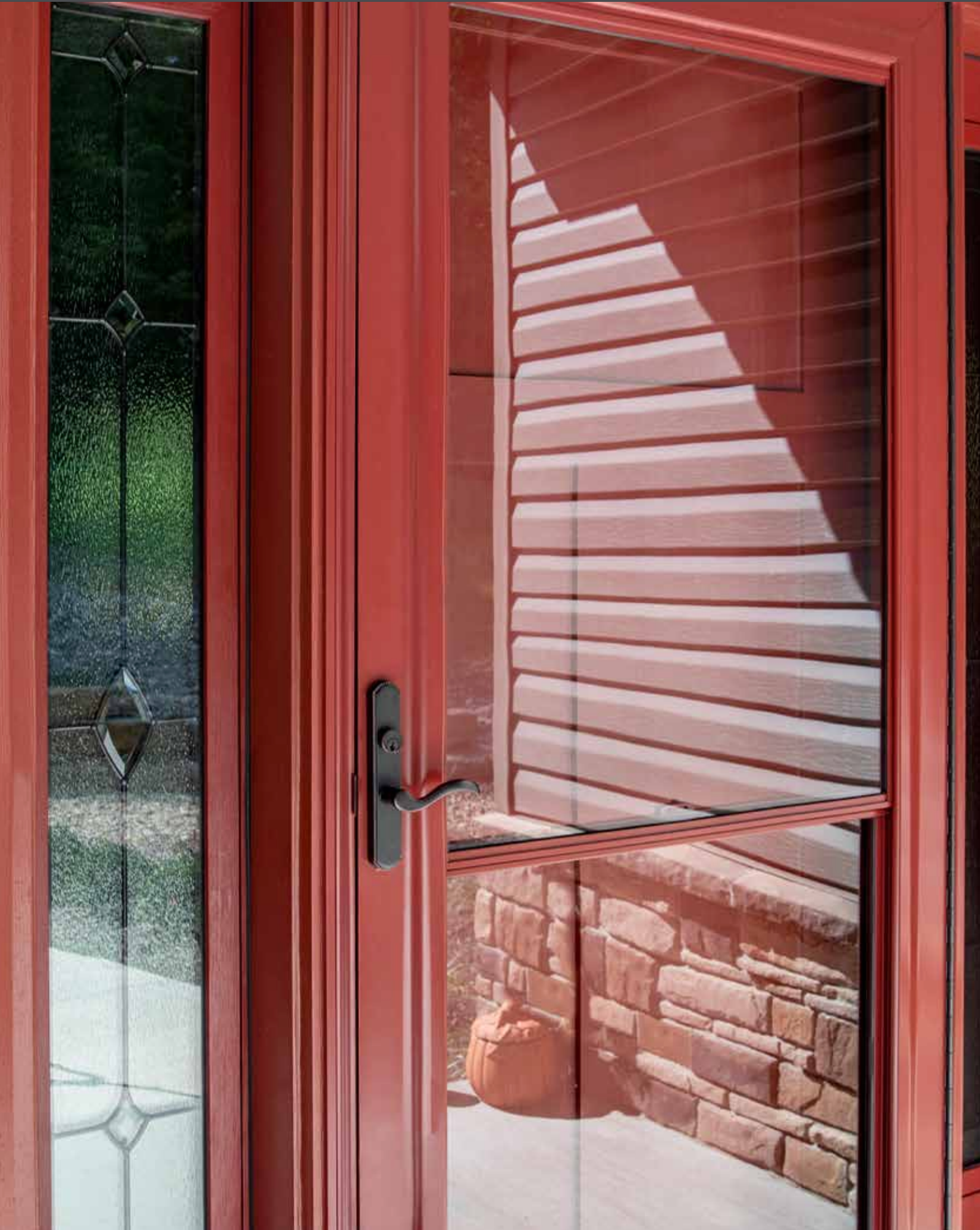 A red door with a reflection of a house in it