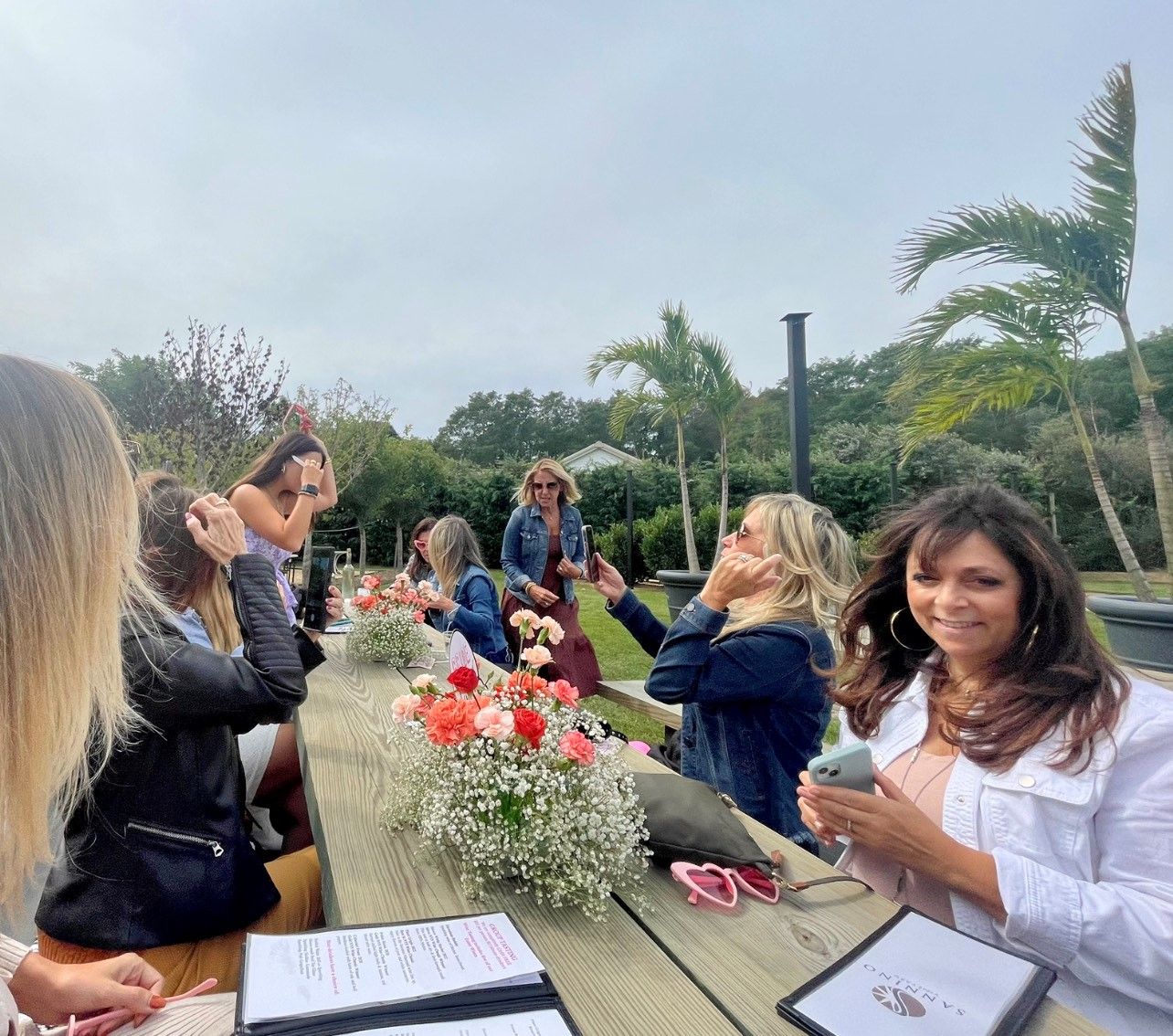 A group of Ladies gathering for sophisticated Bachelorette Celebration outdoors at Sannino Vineyard long table
