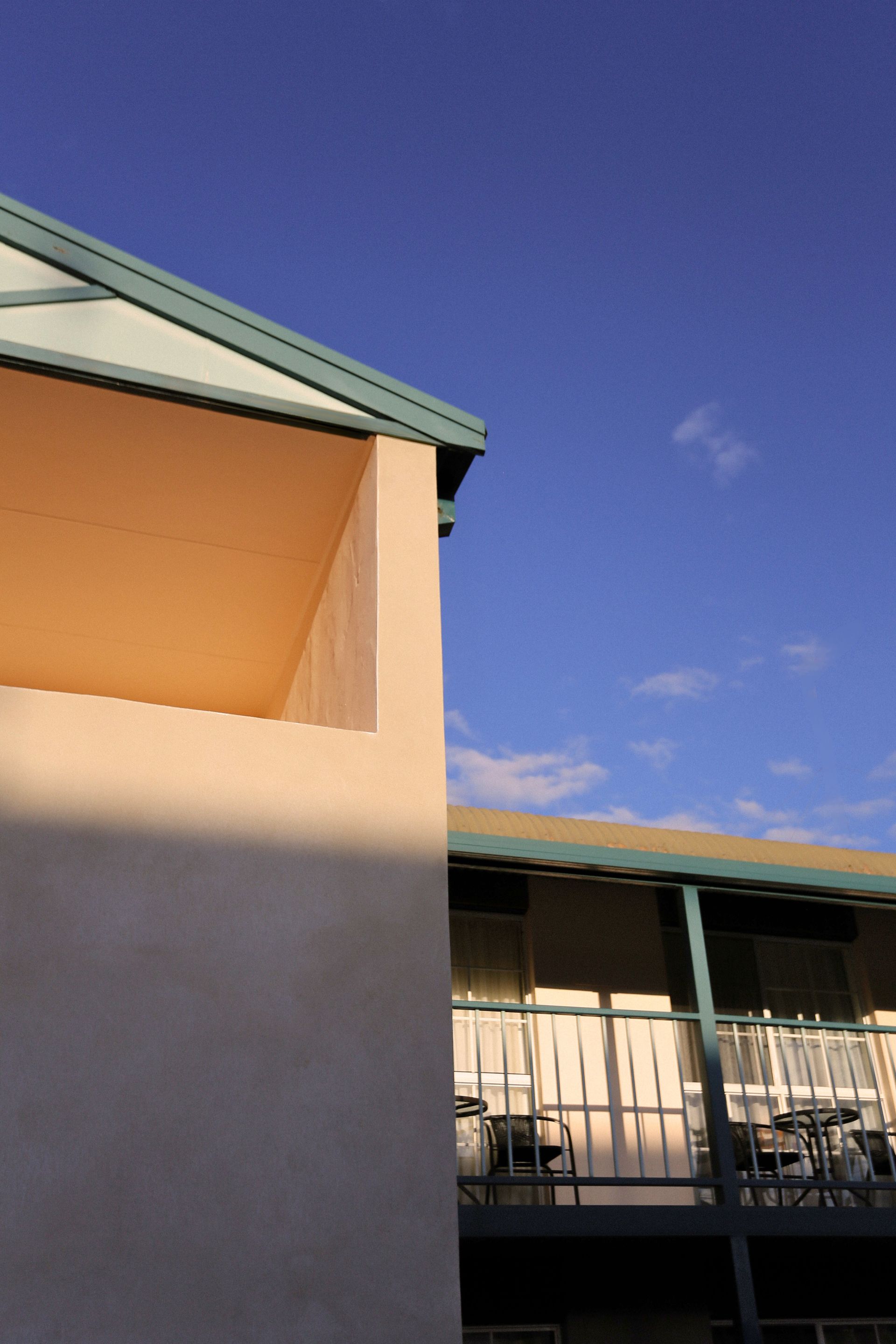 Beige building with blue sky. Light casts shadows.