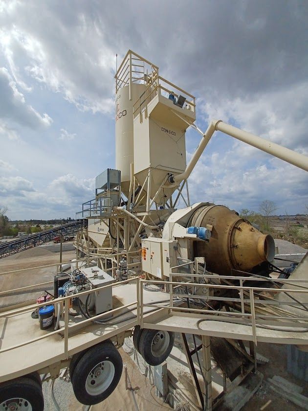 A yellow concrete mixer truck is parked at a construction site.