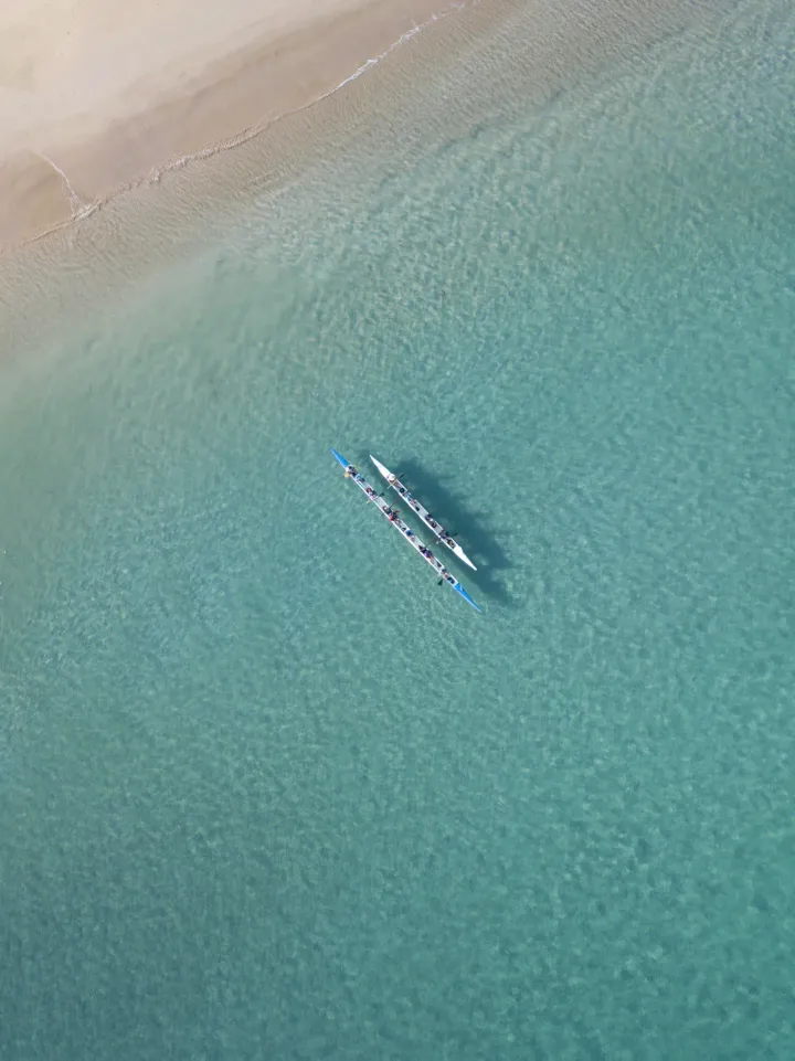 Uma vista aérea de dois caiaques no oceano perto de uma praia.