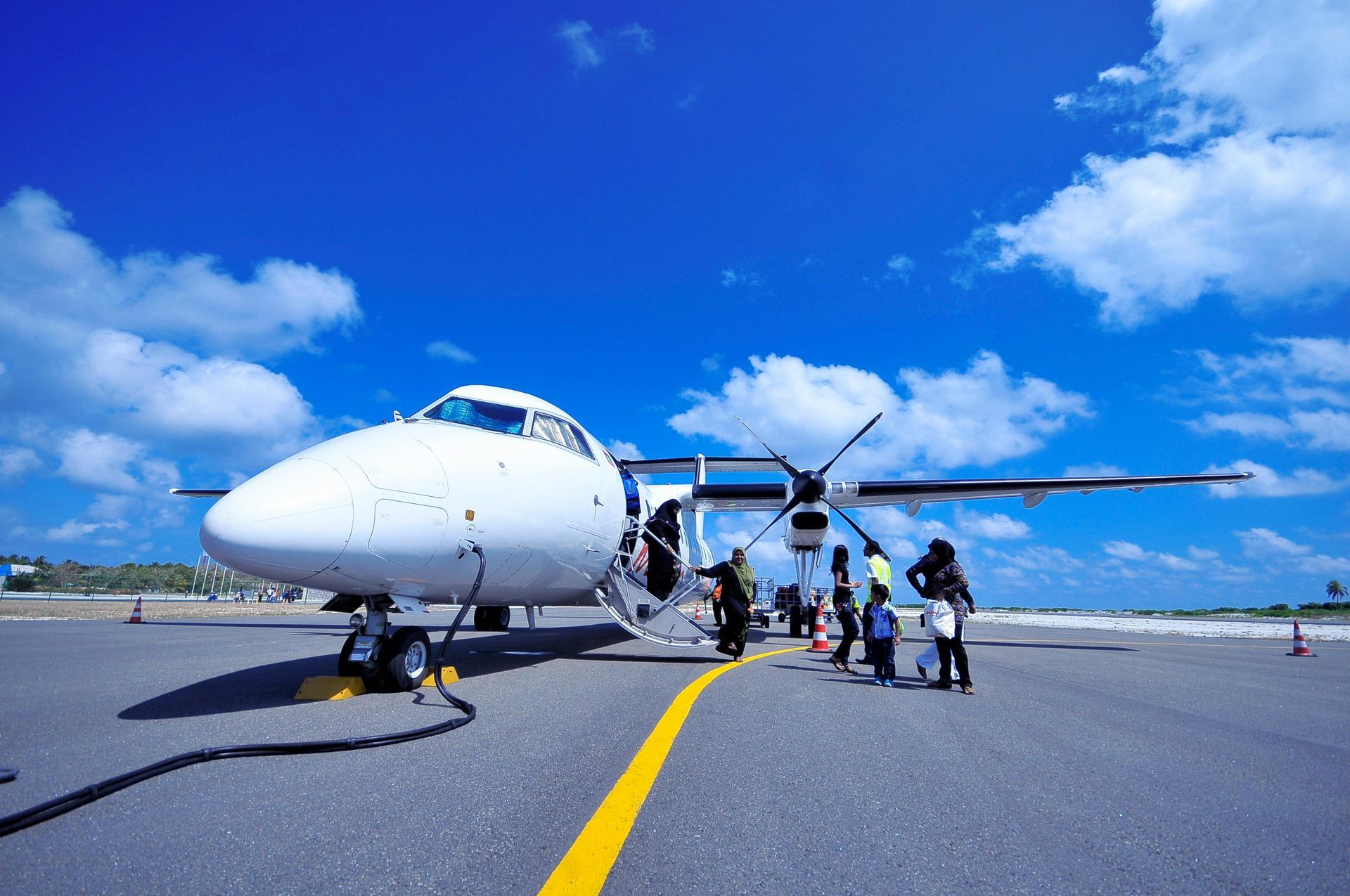 Um grupo de pessoas está embarcando em um avião em uma pista.