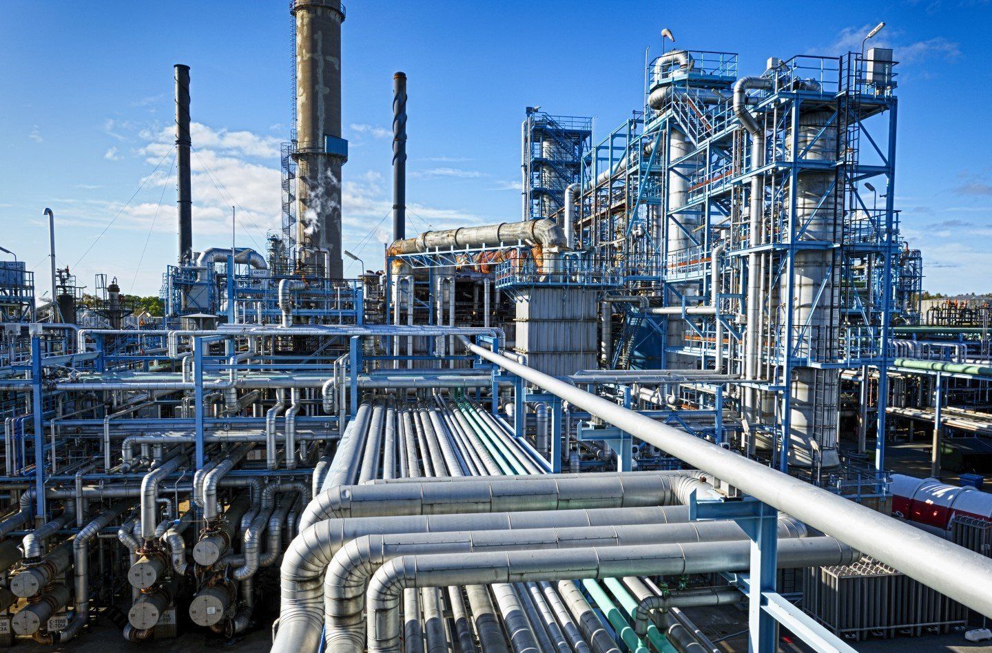 Una grande raffineria di petrolio attraversata da numerosi tubi.