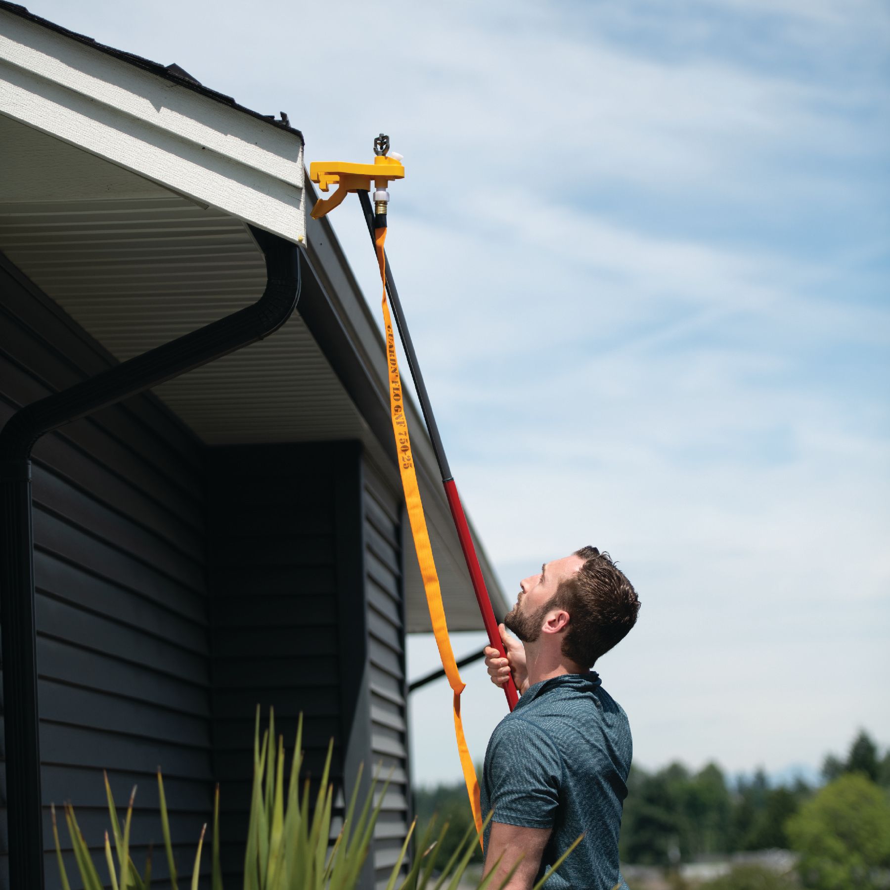 A man is setting up a WASP Gutter Mount Bracket.