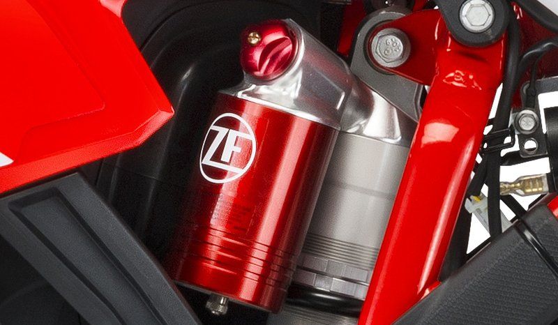 A close up of a red and silver motorcycle shock absorber