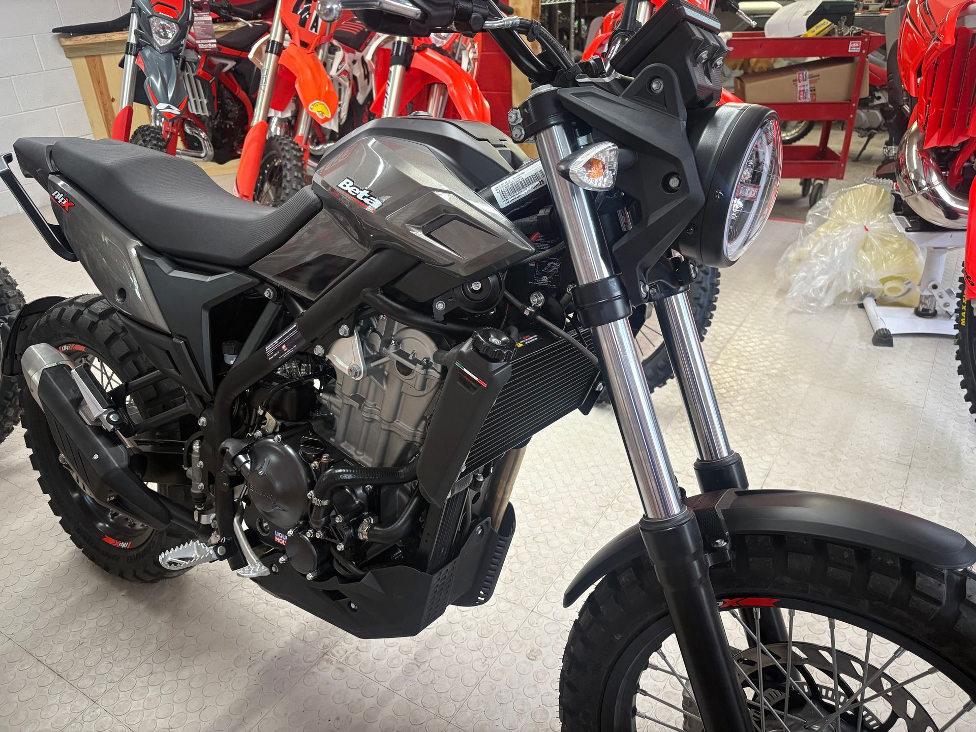 Black sport motorcycle in a showroom, angled front view with other bikes in the background