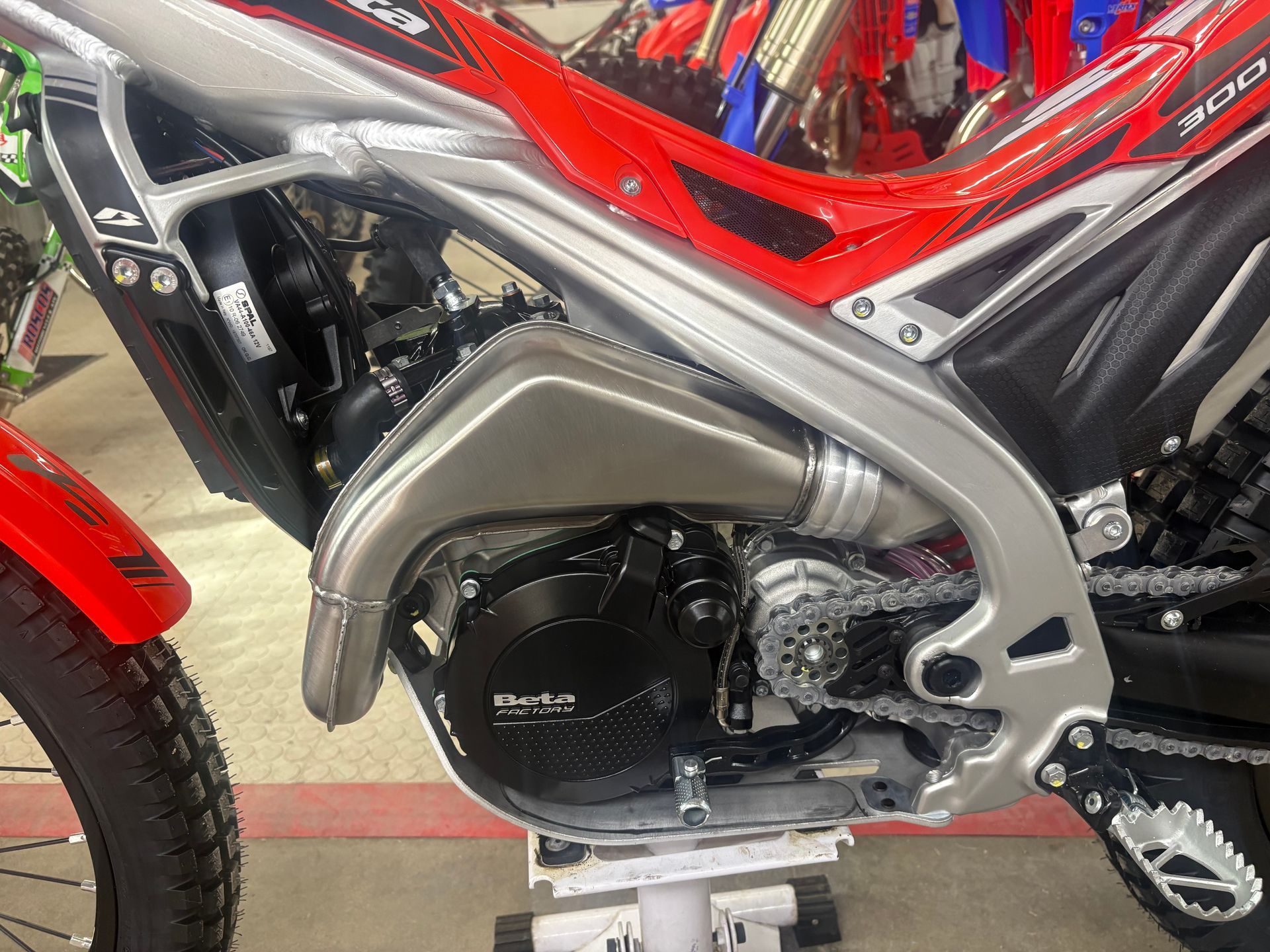 Close-up of a red motorcycle engine and frame with silver exhaust cover and black components