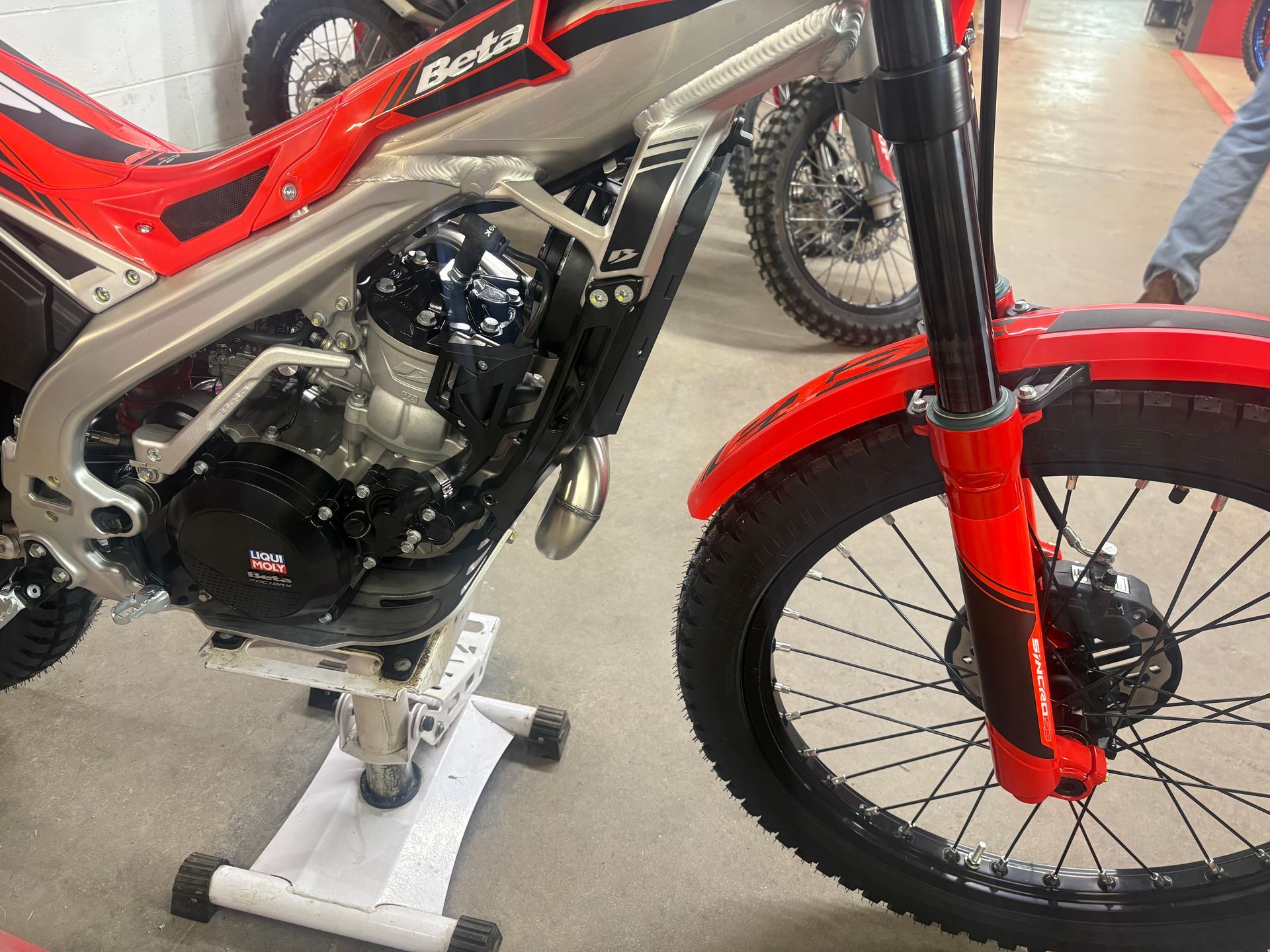 Red and black off-road motorcycle on a display stand in a showroom