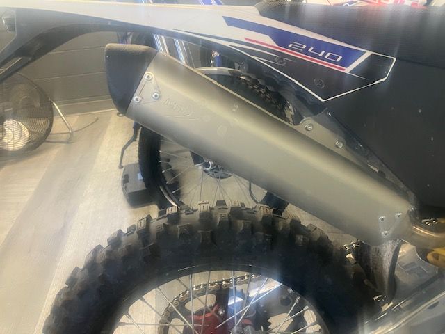 A close up of a motorcycle exhaust pipe and tire.