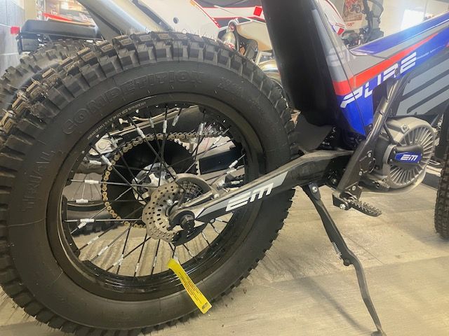 A close up of a motorcycle wheel with a yellow tag attached to it.