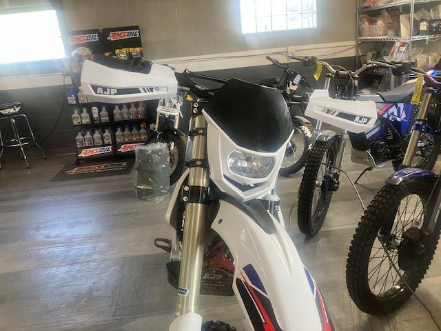 A white dirt bike is parked in a garage.
