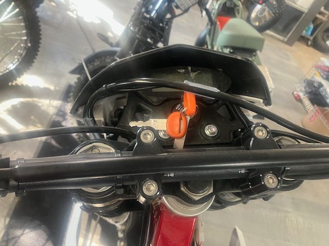 A red dirt bike is parked in a garage.