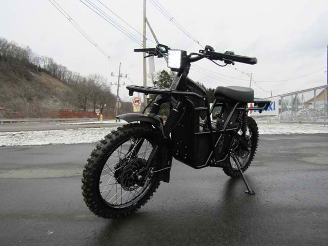 A black dirt bike is parked on the side of the road